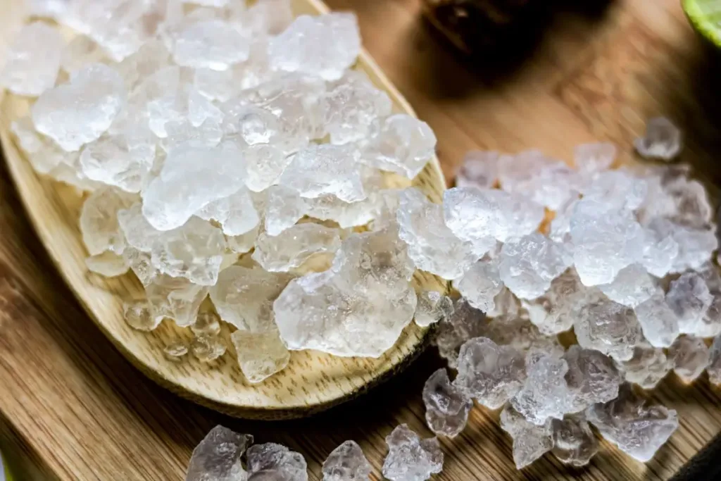 Water kefir grains in a glass jar with sugar water for fermented beverage